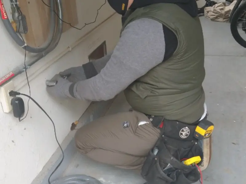 Electrician performing outlet wiring in a Morton garage